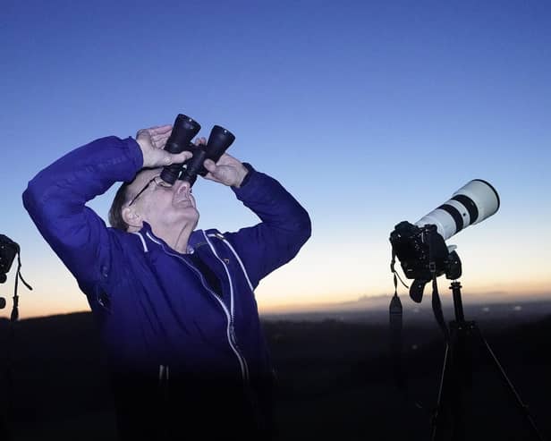 A man scours the night sky with binoculars and camera equipment from the Rock of Dunamase in Co Laois