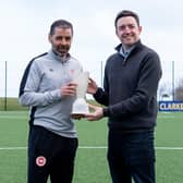 NIFWA Chairman Michael Clarke hands Larne's Tiernan Lynch with the Manager of the Month prize for February