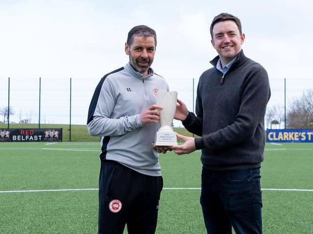 NIFWA Chairman Michael Clarke hands Larne's Tiernan Lynch with the Manager of the Month prize for February