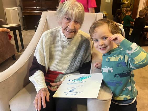 Resident from Oakmont Lodge Care Home learns some drawing skills from a Red Brick House Nursery School pupil as part of a one-of-its-kind pilot scheme that will bring together children aged three to four with older people