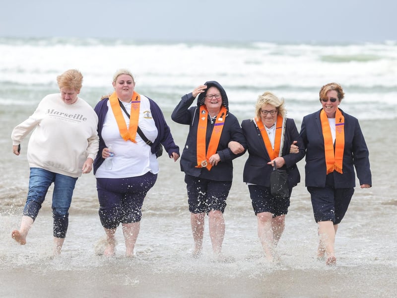 Orange women on the beach take a dip in the Atlantic