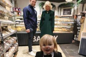 Queen Camilla meets the owner of Knotts Bakery, William Corrie with his son Fitz during a visit to Lisburn Road in Belfast