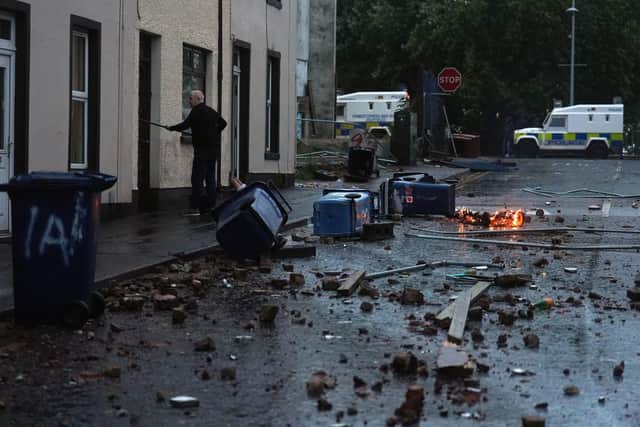 A resident clearing debris Portadown in Co Armagh, following three nights of disorder in Ballymena Photo: Brian Lawless/PA Wire