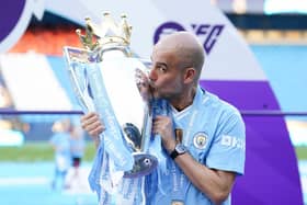 Manchester City manager Pep Guardiola kisses the Premier League trophy after the Premier League match at the Etihad Stadium, Manchester. PIC: Martin Rickett/PA Wire.