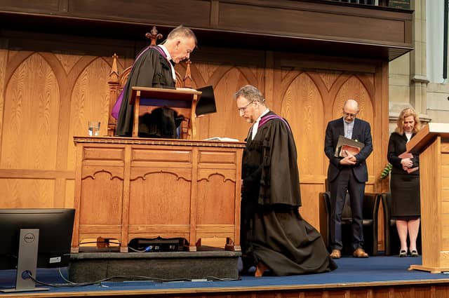 Rt Rev Dr Richard Kerr (kneeling) during his installation service as Moderator as Dr Richard Murray prays for him. (Credit Matthew Audley).