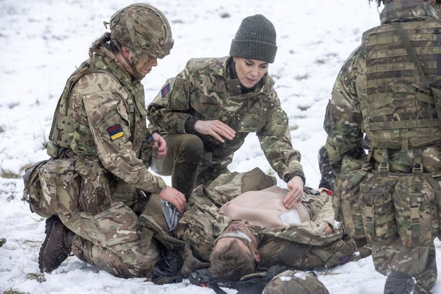 The Princess of Wales, Colonel of the Irish Guards, is shown how to carry out battlefield casualty drills to deliver care to injured soldiers during a casualty simulation exercise