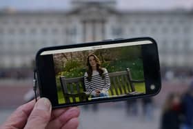 A person watches an announcement on a smart phone outside Buckingham Palace by the Princess of Wales, who has revealed she is undergoing chemotherapy treatment for cancer. She announced the news in a pre-recorded message that was broadcast on Friday evening