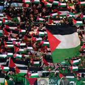 Celtic fans in the stands wave flags of Palestine during Wednesday's Champions League game against Atletico Madrid