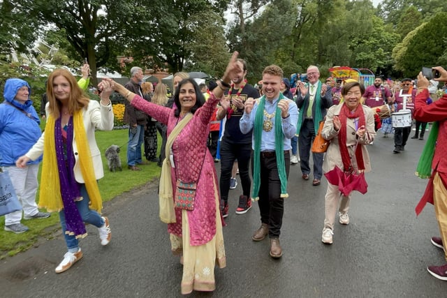 Belfast Mela founder Nisha Tandon (centre) leads the opening procession of the event on Sunday in Botanic Gardens, alongside head of the Northern Ireland Civil Service Jayne Brady (left) and Belfast Lord Mayor Ryan Murphy (right)