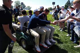 Rory McIlroy interacts with fans as he leaves the Aronimink course in a cart during Tuesday's practice round. (Photo by Emilee Chinn/Getty Images)
