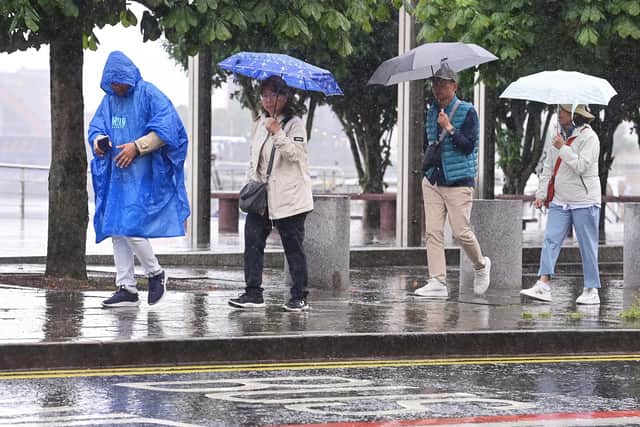 Tourists sheltering from the rain during a summer downpour in Belfast