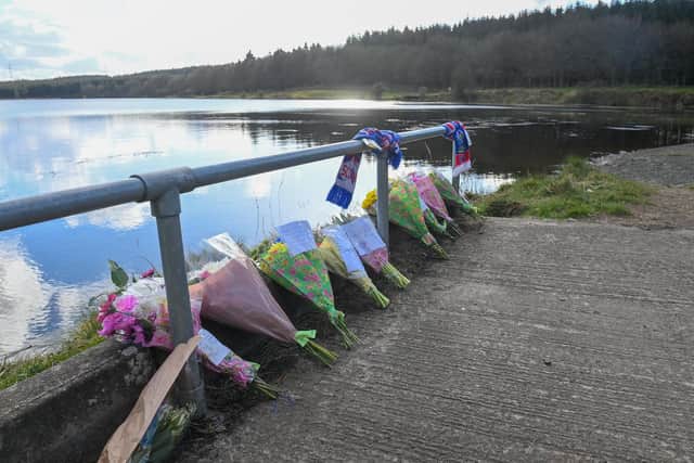 Flowers laid at the scene where the the body of Roy Reynolds was found at Woodburn Reservoir in Carrickfergus in 2022
