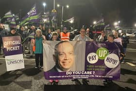 Striking Unison members in Northern Ireland with a banner urging Secretary of State Chris Heaton-Harris to 'pay up'