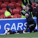 Glentoran's Bobby Burns receives treatment after colliding with a perimeter hoarding at Seaview on Saturday. (Photo by David Maginnis/Pacemaker Press)