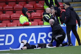 Glentoran's Bobby Burns receives treatment after colliding with a perimeter hoarding at Seaview on Saturday. (Photo by David Maginnis/Pacemaker Press)