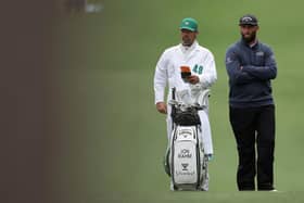 Jon Rahm talks with his caddie Adam Hayes on the first hole during the third round of the 2023 Masters Tournament at Augusta National Golf Club.