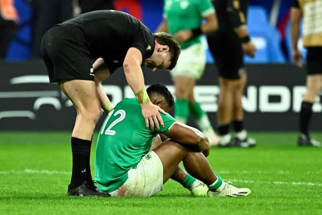 Ireland's inside centre Bundee Aki (R) is consoled by New Zealand's inside centre Jordie Barrett (L) after New Zealand won the France 2023 Rugby World Cup quarter-final match between Ireland and New Zealand at the Stade de France in Saint-Denis. (Photo by JULIEN DE ROSA/AFP via Getty Images)