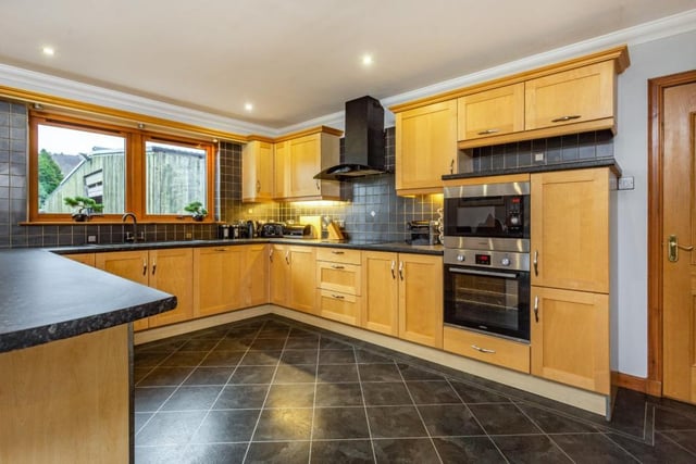 The kitchen provides a range of wall and base units and includes a breakfast bar.
