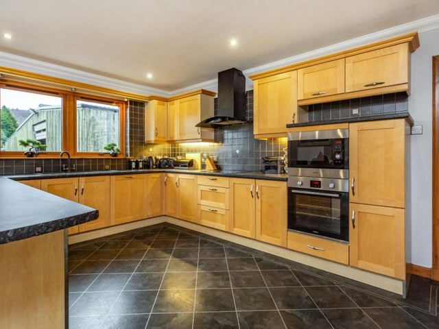 The kitchen provides a range of wall and base units and includes a breakfast bar.