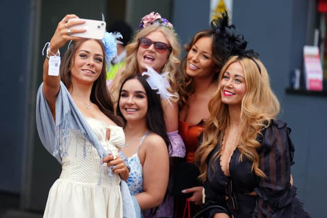 Racegoers take a selfie during the 2024 Randox Grand National Festival at Aintree Racecourse, Liverpool. (Photo by Mike Egerton/PA Wire)
