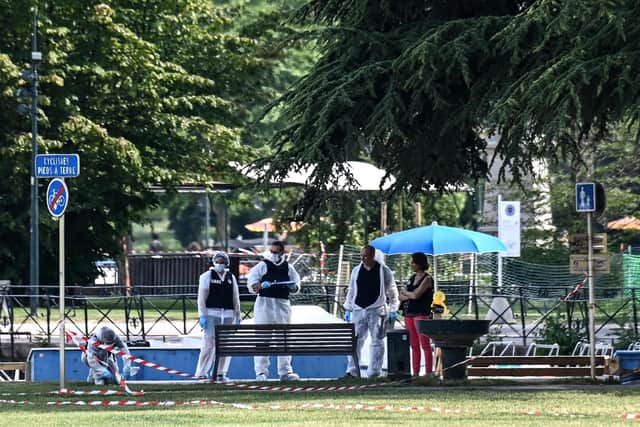 French forensic police officers work at the scene of a stabbing attack in the 'Jardins de l'Europe' park in Annecy, in the French Alps