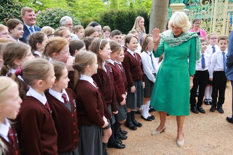 Queen Camilla greets school children during a visit to open the new Coronation Garden on day one of their two-day visit to Northern Ireland on May 24, 2023 in Newtownabbey, Northern Ireland. King Charles III and Queen Camilla are visiting Northern Ireland for the first time since their Coronation. Their Majesties will met designers of the Garden and representatives of community and charitable organisations, hearing how the Garden marks the beginning of a new green initiative for the Antrim and Newtownabbey Borough Council. (Photo by Chris Jackson/Getty Images)
