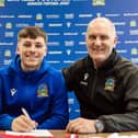 Linfield striker Chris McKee puts pen to paper on a new two-year contract at the National Stadium. He is pictured with chief scout Willie McKeown. PIC: Pacemaker