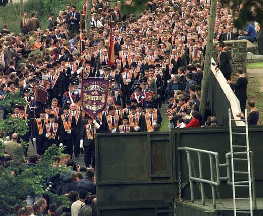 Members of the Orange Order from the Portadown District marching from Drumcree Church towards the barricade blocking their route along the nationalist Garvaghy Road in 1998.