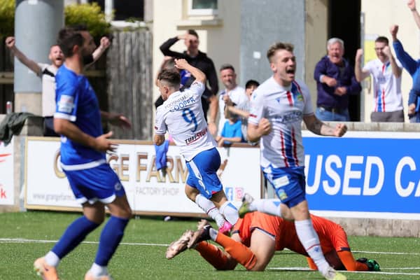 Dungannon Swifts captain Chris Hegarty (left) can only look on as Joel Cooper fires Linfield 2-1 ahead at Stangmore Park