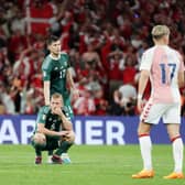 Northern Ireland’s George Saville and Paddy McNair (standing) after a late goal is ruled out by VAR in defeat to Denmark