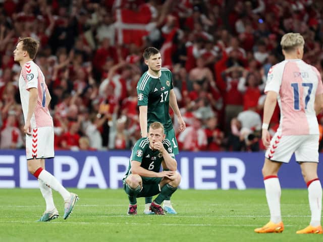 Northern Ireland’s George Saville and Paddy McNair (standing) after a late goal is ruled out by VAR in defeat to Denmark