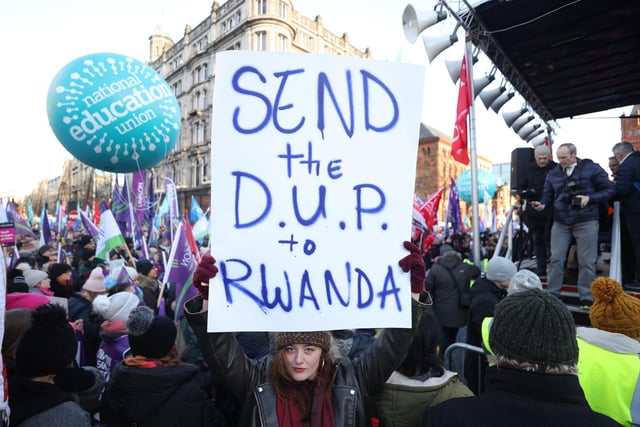 A protester holds a sign outside Belfast City Hall, Belfast, as an estimated 150,000 workers take part in walkouts over pay across Northern Ireland.