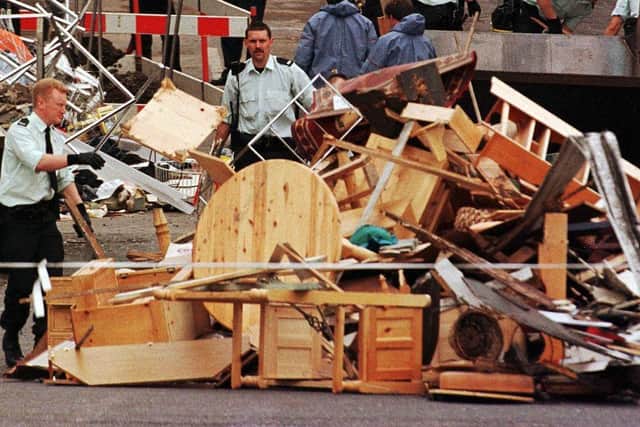 Officers of the Royal Ulster Constabulary (RUC) pile up damaged furniture during the clean-up operation in Omagh after a car bomb explosion killed 28
