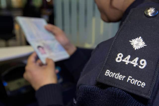 Border Force officer checking passports of arrival passengers