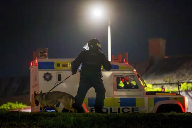 A PSNI officer and dog during a third night of disorder in Ballymena, Co Antrim. Photo: Liam McBurney/PA Wire