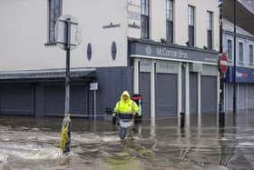 Gerry Peers uses a guide rope to cross through flood water on Bank Parade in Newry Town, Co Down.