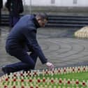 Northern Ireland Veterans Commissioner David Johnston places a remembrance cross at Belfast City Hall. Photo: Liam McBurney/Press Association