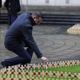 Northern Ireland Veterans Commissioner David Johnston places a remembrance cross at Belfast City Hall. Photo: Liam McBurney/Press Association