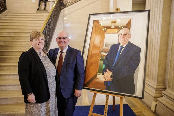 Former Stormont Assembly speaker Lord William Hay and Lady Hay stand beside a portrait of himself, painted by Stephen Johnston, as it is unveiled at Parliament Buildings in Belfast