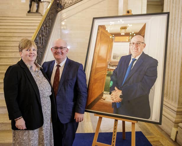 Former Stormont Assembly speaker Lord William Hay and Lady Hay stand beside a portrait of himself, painted by Stephen Johnston, as it is unveiled at Parliament Buildings in Belfast