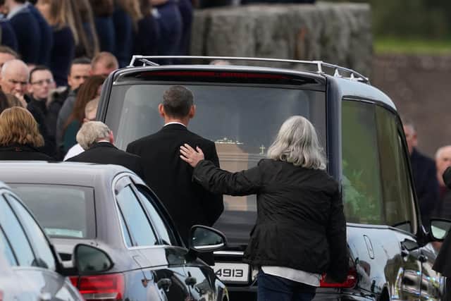 Mourners comfort each other as they arrive for the funeral mass of James Monaghan and and his mother Catherine O'Donnell at St Michael's Church, Creeslough.