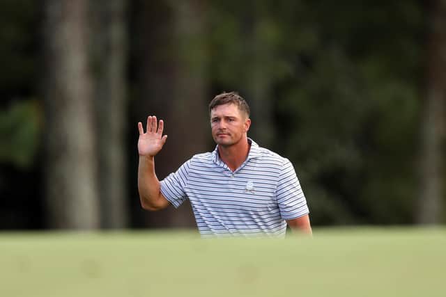 Bryson DeChambeau waves to the patrons on the 18th green during the first round of the Masters