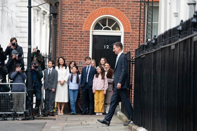 Jack Hunt (third from left), Lucia Hunt (fourth from left), Anna Hunt (sixth from left) and Eleanor Hunt (fourth from right) watch Chancellor of the Exchequer Jeremy Hunt outside 11 Downing Street, London, with his ministerial box before delivering his Budget in the Houses of Parliament. Photo : Stefan Rousseau/PA Wire