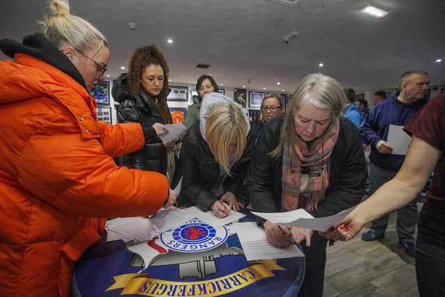 Community worker and activist Jamie Lee Mogey (left) at Carrickfergus Glasgow Rangers Supporters Club, collecting signed letters. Picture: Liam McBurney/PA Wire