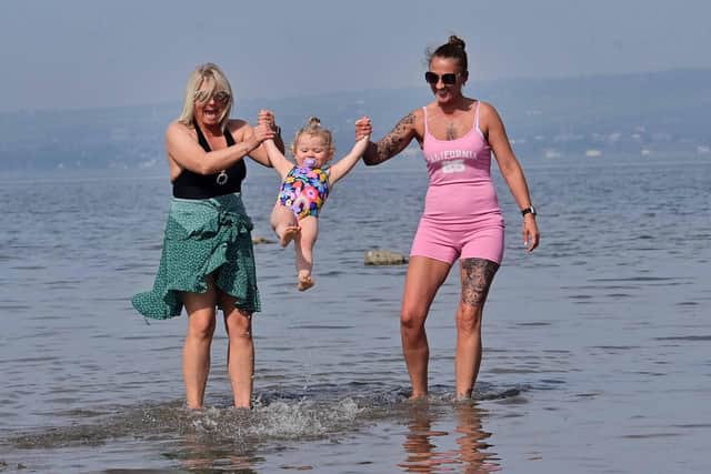 Teddi Sheridan (aged 2) with Carrie Orr and Joeleen McFerran cooling down during the warm weather at Seapark near Holywood in Co Down. Pic Colm Lenaghan/Pacemaker