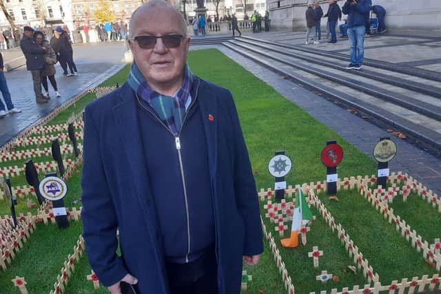 Rev Chris Hudson of All Souls non-subscribing Presbyterian church in Belfast pays his respects at the Field of Remembrance in the grounds of Belfast City on Armistice Day, Saturday November 11, 2023. In the background on the left of the picture is a poppy cross planted in the Jewish Military Association UK part of the field and on the right crosses in the Irish Guards Association section, with a Tricolour