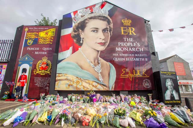 Flowers and tributes are pictured by a mural on the Shankill road, in Belfast, September 9, 2022, a day after Queen Elizabeth II died at the age of 96. - Queen Elizabeth II, the longest-serving monarch in British history and an icon instantly recognisable to billions of people around the world, died at her Scottish Highland retreat on September 8. (Photo by PAUL FAITH / AFP) (Photo by PAUL FAITH/AFP via Getty Images)