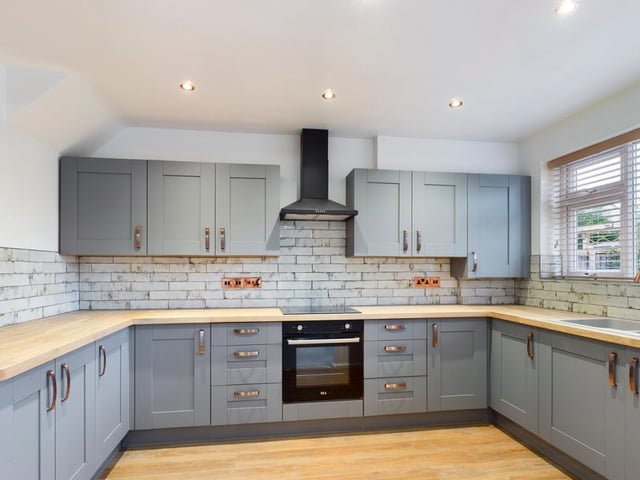 The first room we look at is the newly-fitted kitchen, which features integrated appliances, including an electric oven with four-ring induction hob and extractor hood over, and a fridge freezer. There's a range of modern, matching wall and base units, with a solid-wood work surface incorporating a one-and-a-half sink drainer with chrome mixer tap. Laminate wood-effect flooring and ceiling spotlights add to the kitchen's appeal.