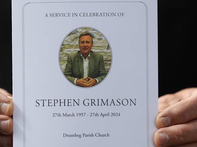 A mourner holds the order of service for the the funeral mass of former BBC Northern Ireland political editor and director of communications at Stormont, Stephen Grimason, at Drumbeg Parish Church in Dunmurry