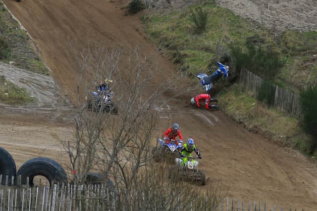 Justin Reid (14) and Dean Dillon (136) were unaware that Mark McLernon had crashed in the opening quad race. McLernon was unhurt and remounted to finish third.